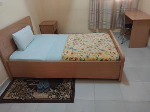 Cette chambre comprend un lit avec un cadre en bois. dans l'établissement Centre d'Accueil Bonne Esperance Rwanda, à Kigali