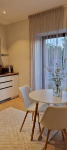 una sala da pranzo con tavolo, sedie e finestra di Albatross Green Apartment a Ķesterciems