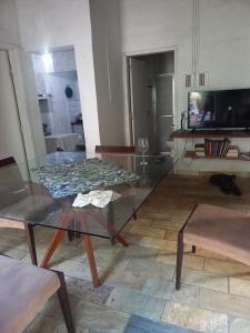 uma sala de estar com uma mesa de vidro e uma televisão em CASA DE PRAIA em São Sebastião