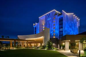 VEA Newport Beach, a Marriott Resort & Spa في شاطئ نيوبورت: فندق به مبنى ضوء أزرق في الليل