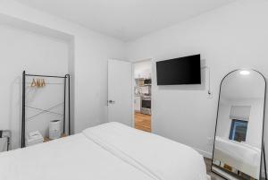 um quarto branco com uma cama e um espelho em Calm Urban Abode steps to Volunteer Park em Seattle