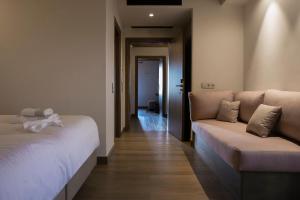 a room with a bed and a couch and a hallway at Μikri Arktos Boutique Hotel in Dhimitsana