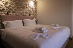 a bedroom with a bed with towels on it at Μikri Arktos Boutique Hotel in Dhimitsana