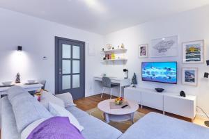 a white living room with a couch and a table at Apartman Maksimir in Zagreb