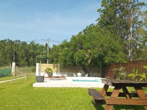 un patio trasero con mesa de picnic y piscina en Casa de Campo La Amada en Federación