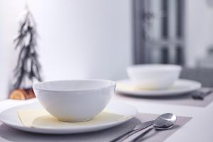 un tavolo con due ciotole bianche e un cucchiaio di Apartman “Maksimir” a Zagabria
