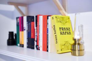 una fila di libri seduti su uno scaffale con una luce di Apartman “Maksimir” a Zagabria