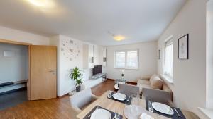 a dining room and living room with a table and chairs at CROWN LIVING Design Apartment - gratis Parkplatz - WLan - Küche - Self Check-in in Dornbirn