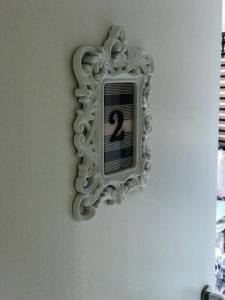 une horloge sur le côté d'un mur avec un miroir dans l'établissement República Descolada! Quarto exclusivo p/ mulheres!, à Florianópolis