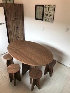 une table en bois et quatre tabourets dans une pièce dans l'établissement República Descolada! Quarto exclusivo p/ mulheres!, à Florianópolis
