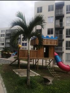 a tree house with a slide and a playground at Comodidad y tranquilidad in Ibagué