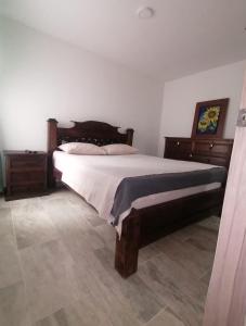 ein Schlafzimmer mit einem großen Bett und Holzmöbeln in der Unterkunft Comodidad y tranquilidad in Ibagué