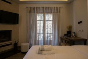 a hotel room with a bed and a window at Μikri Arktos Boutique Hotel in Dhimitsana