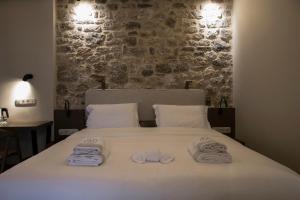 a bedroom with a bed with towels on it at Μikri Arktos Boutique Hotel in Dhimitsana