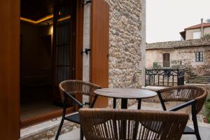 a patio with a table and chairs on a balcony at Μikri Arktos Boutique Hotel in Dhimitsana