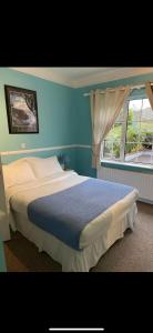 1 dormitorio con 1 cama grande y ventana en Kinsale B&B en Scilly