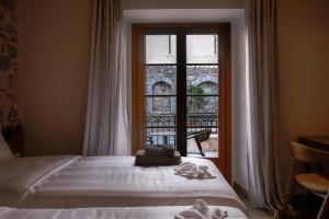 a bedroom with a bed in front of a window at Μikri Arktos Boutique Hotel in Dhimitsana