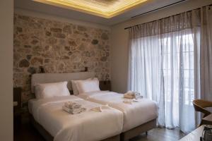 a bedroom with two beds and a large window at Μikri Arktos Boutique Hotel in Dhimitsana
