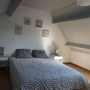 a bedroom with a bed with a black and white comforter at Les Aigrettes, en plein centre, à 200m de la plage in Saint-Vaast-la-Hougue