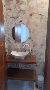 a bathroom with a sink and a mirror at Suítes da Alcy in Caraíva