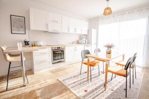 a kitchen with white cabinets and a table and chairs at Villa Greux - 6 personnes - New in Montlouis-sur-Loire