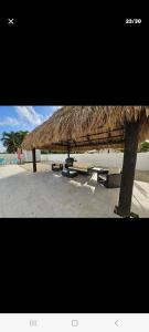 a straw umbrella on a beach with a table at Villa hermosa in Key Largo