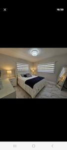 a bedroom with a large bed and two windows at Villa hermosa in Key Largo
