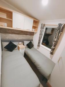 two beds in a small room with a window at Hillingworth's Hot Tub Retreat - Lochmaben in Dumfries