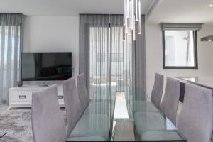 jadalnia ze szklanym stołem i krzesłami w obiekcie Luxury 2BR Seaviews - Santa Barbara Heights w mieście Fuengirola