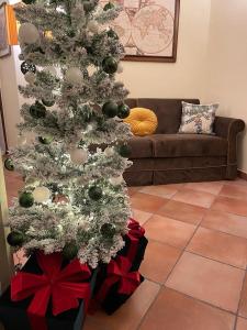 un árbol de Navidad en una sala de estar con regalos debajo en Torre delle rondini, en Castelnuovo di Farfa