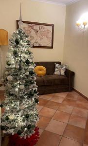 un árbol de Navidad en una sala de estar con sofá en Torre delle rondini, en Castelnuovo di Farfa