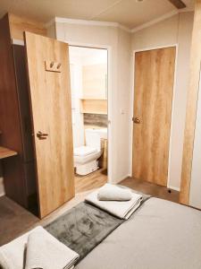 a bathroom with a toilet and a bed in a room at Hillingworth's Hot Tub Retreat - Lochmaben in Dumfries