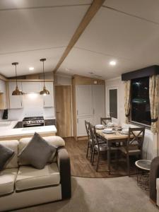 a kitchen and living room with a couch and a table at Hillingworth's Hot Tub Retreat - Lochmaben in Dumfries