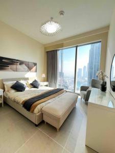 um quarto com uma cama grande e uma janela grande em Brand new 2B/R with Burj Khalifa and Fountain View no Dubai