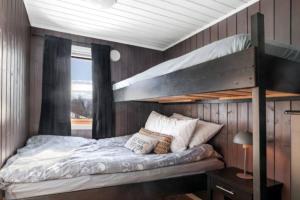 a bedroom with a bunk bed and a window at Hytte paradis i Kviby in Kviby