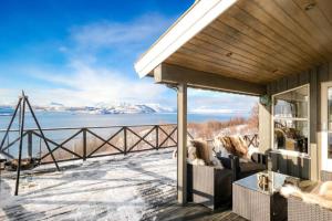a house with a balcony with a view of the water at Hytte paradis i Kviby in Kviby