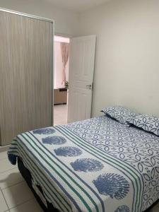 1 dormitorio con 1 cama con manta azul y blanca en Apt no Icaraí mobiliado de frente para a praia., en Caucaia