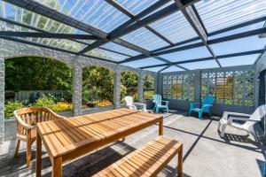 a pergola with a wooden table and chairs on a patio at Town Studio in Taupo +2 photos