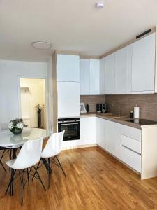 a kitchen with white cabinets and a table and chairs at Danube22 Apartment 2 in Vienna
