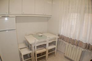 een kleine witte keuken met een tafel en een koelkast bij Apartamento La Luz de Reinosa 1 in Reinosa