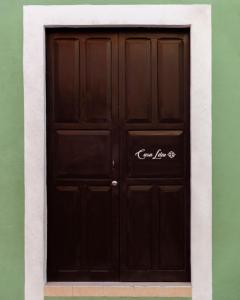 Una puerta negra en una pared verde con un cartel. en Casa Lilia, ubicada en el Centro Histórico, en Campeche