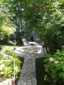 a patio with chairs and a table in a garden at Apartment Milinkovic in Kovanluk
