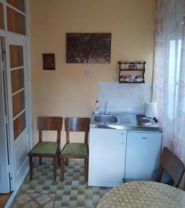 eine Küche mit einem Waschbecken, 2 Stühlen und einem Tisch in der Unterkunft Apartment Milinkovic in Kovanluk