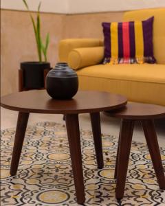 two tables in a living room with a couch at Casa Lilia, ubicada en el Centro Histórico in Campeche