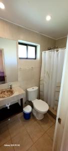La salle de bains est pourvue de toilettes, d'un lavabo et d'une fenêtre. dans l'établissement Habitaciones Tahiken, à Olmué