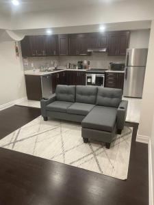 a living room with a couch and a chair and a kitchen at Zen Nest in Brampton