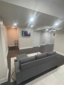 a living room with a couch and a flat screen tv at Zen Nest in Brampton