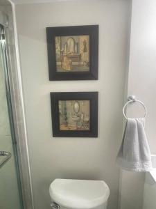 a bathroom with a toilet and two pictures on the wall at Zen Nest in Brampton