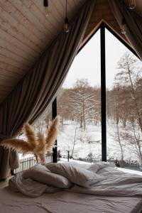 łóżko w pokoju z dużym oknem w obiekcie Domki Momenty w mieście Słajszewo