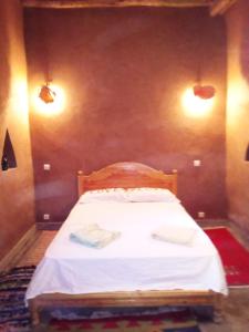 a small bed in a room with two lights at Casa Familia in Zagora
